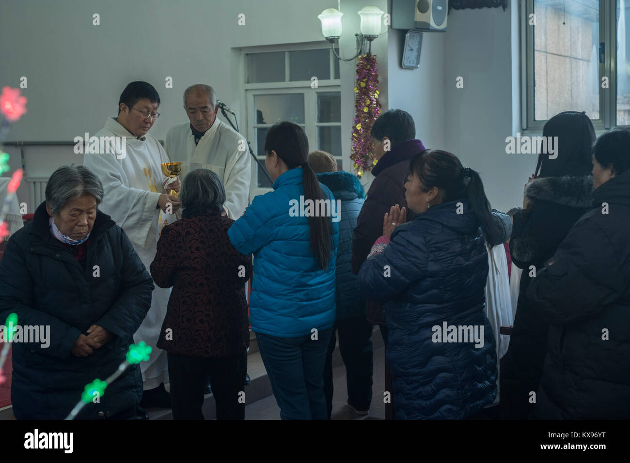 Der Reverend Pang Ruowang, die Gemeinschaft der Gläubigen, während der Christmette am Heiligen Herz Jesu Kirche in Housangyu Dorf, 70 km westlich von Peking, eine der frühesten Kirchen in China. 25-Dez-2017 Stockfoto