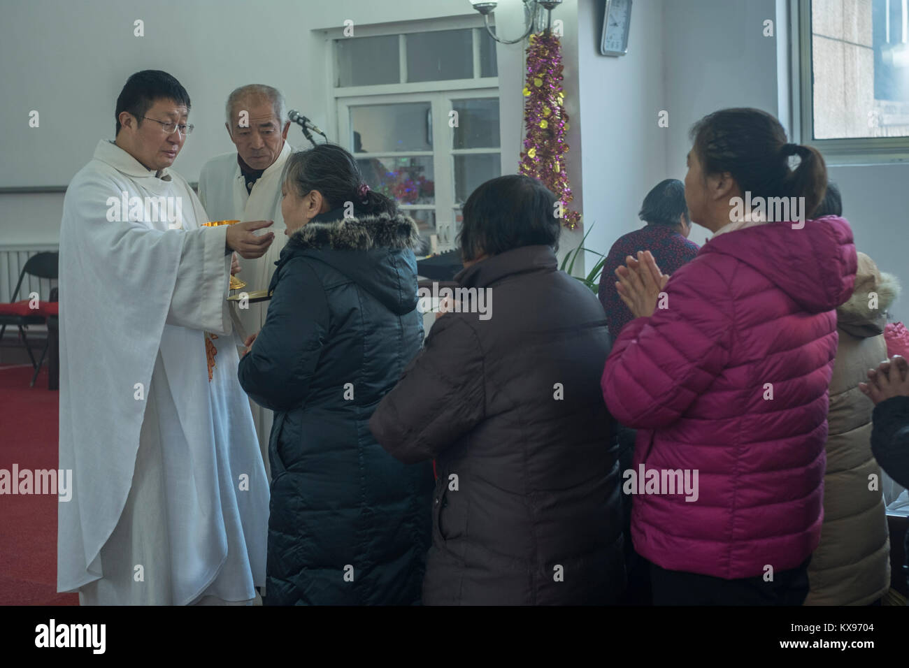 Der Reverend Pang Ruowang, die Gemeinschaft der Gläubigen, während der Christmette am Heiligen Herz Jesu Kirche in Housangyu Dorf, 70 km westlich von Peking, eine der frühesten Kirchen in China. 25-Dez-2017 Stockfoto