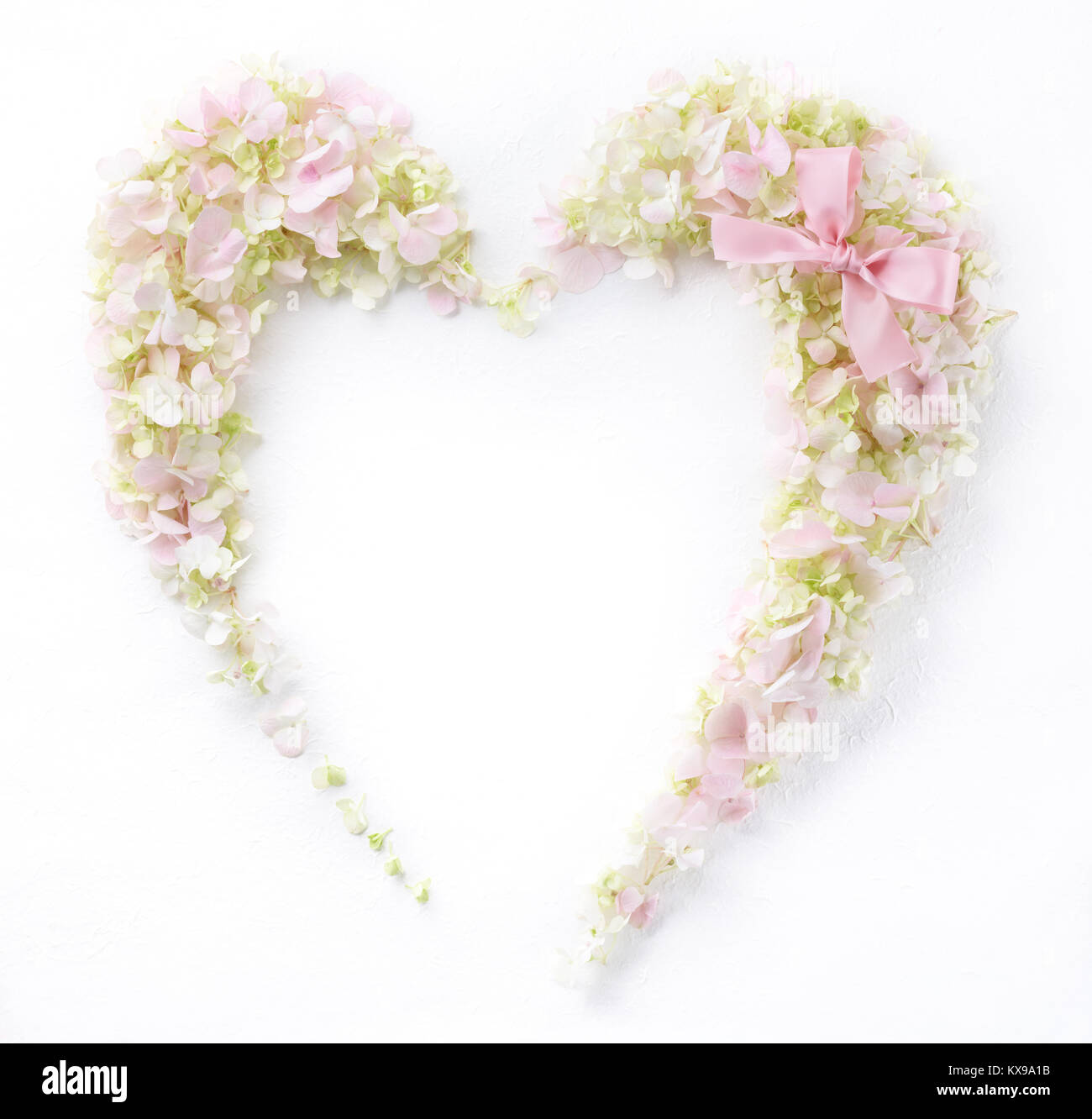 Herz aus Blüten mit Geschenk Schleife Stockfoto