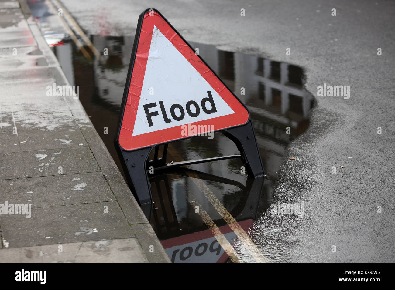 Eine Flut Warndreieck dargestellt sitzen in einer kleinen Überschwemmung in Chichester, West Sussex, UK. Stockfoto