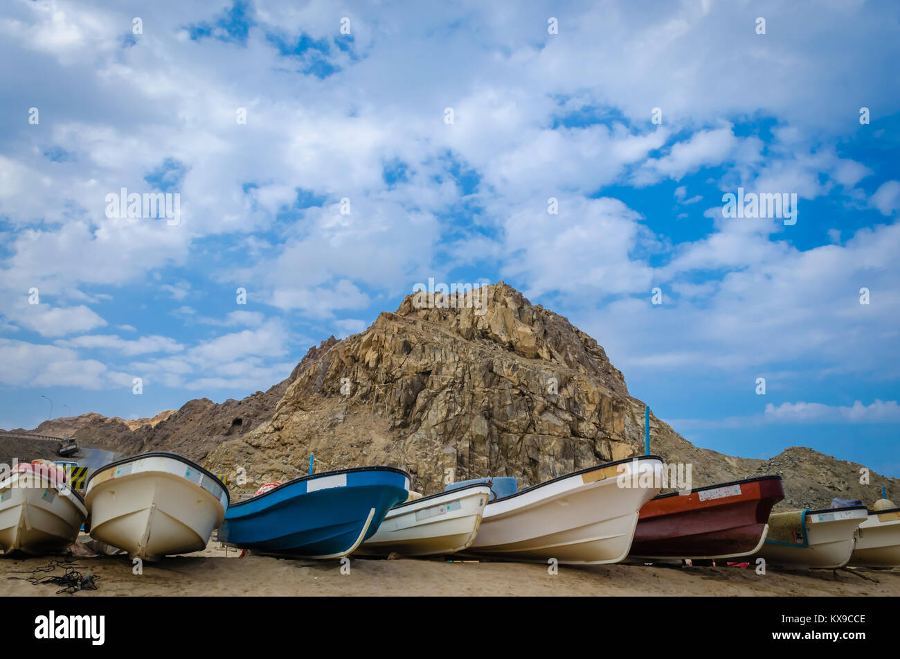 Fischerboote am Strand mit einem Hügel und ein bewölkter Himmel im Hintergrund. Stockfoto