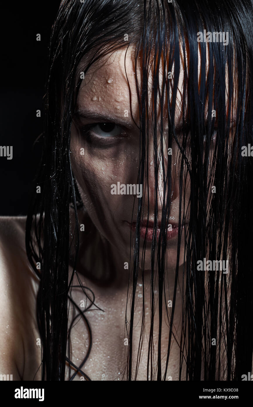 Ernsthafte wütende Frau mit nassen schwarzen Haar an Kamera Stockfoto