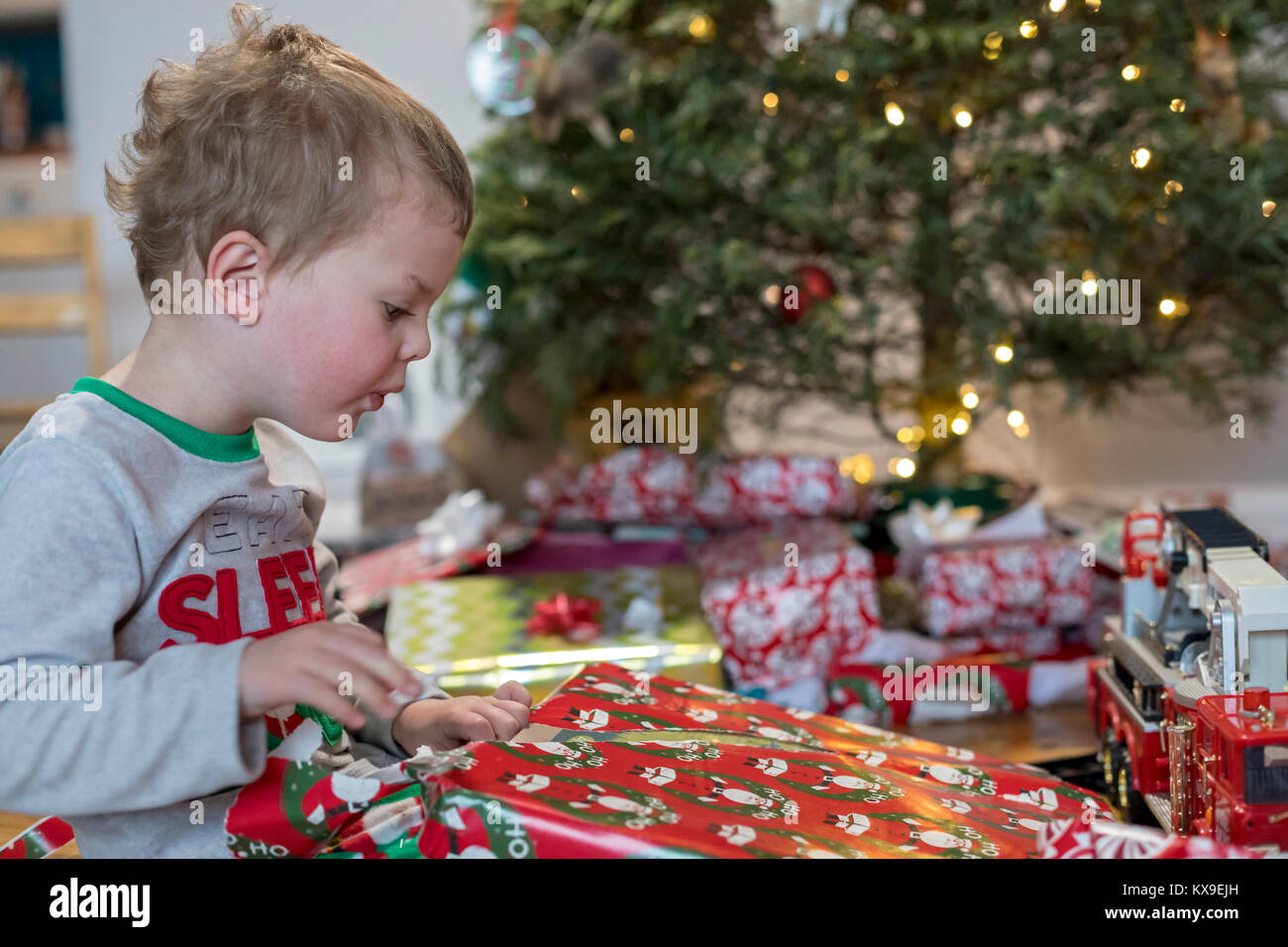 Wheat Ridge, Colorado - Adam Hjermstad jr., 3, geöffnet, präsentiert von Weihnachtsbaum seiner Familie auf Weihnachten Morgen. Stockfoto