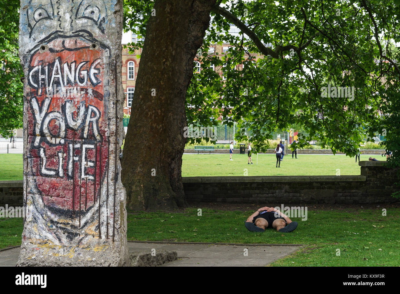 Ein Mann auf der Rückseite neben der Street Art Installation ändern Ihr Leben liegt. Stockfoto