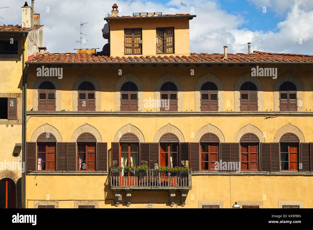 Teil der Fassade eines alten italienischen Gebäude in Florenz mit gewölbten Fenstern und Balkon Stockfoto