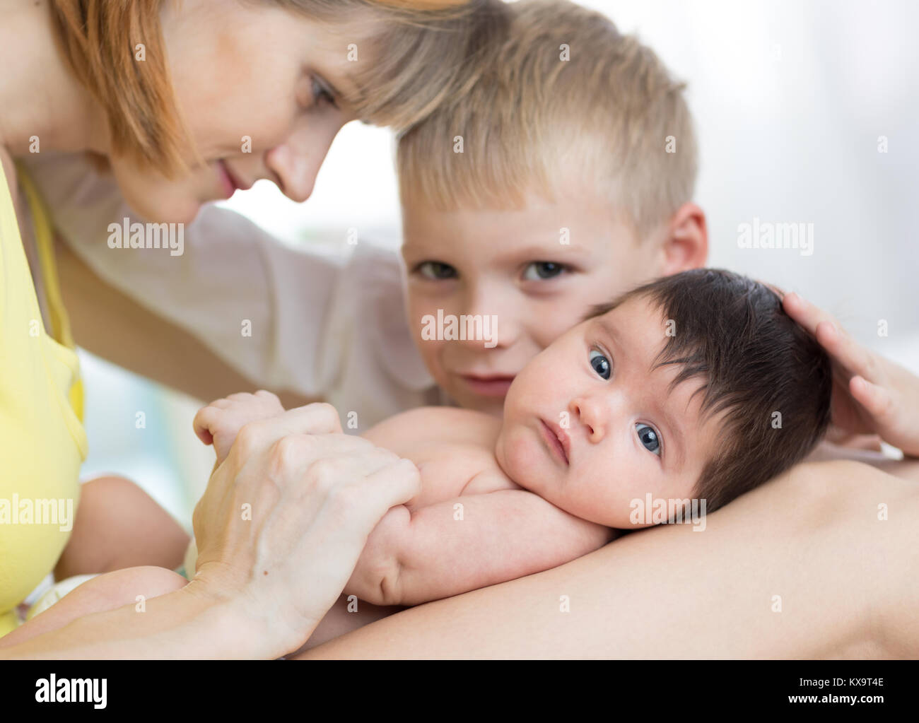 Nahaufnahme der glücklichen Familie. Freudige Mama, die Ihr Kind Sohn und neugeborenes Baby zusammen Stockfoto