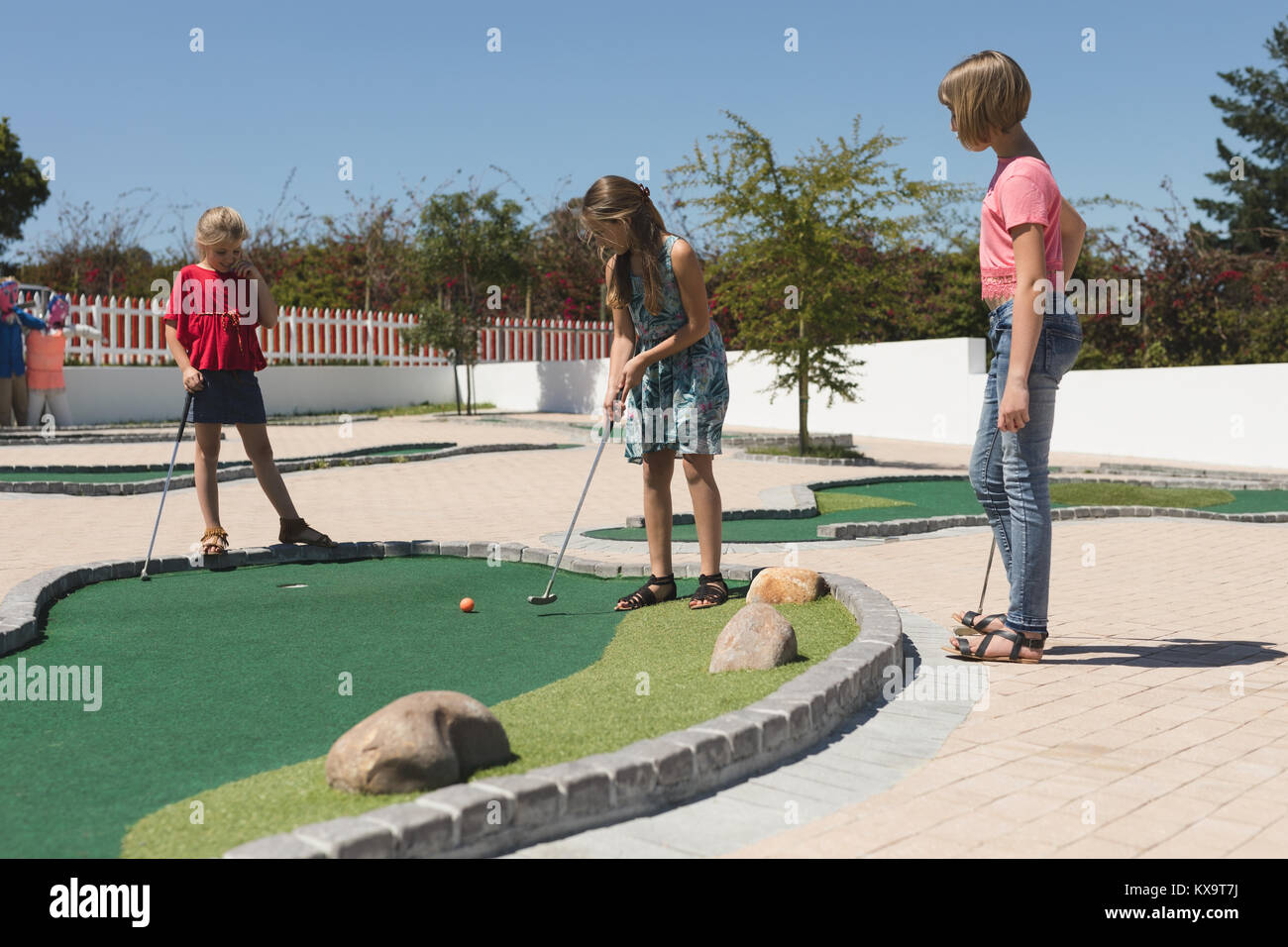 Kinder Golf spielen auf dem Spielplatz Stockfoto