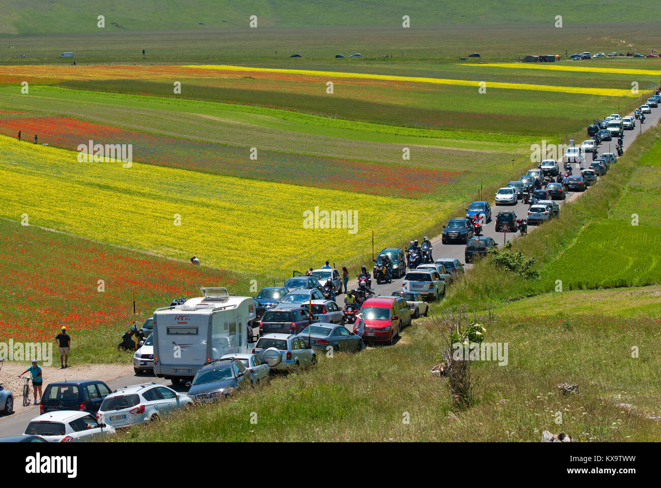 Eine Menge Autos und Menschen in Castelluccio Di Norcia während der Blütezeit im Pian Grande, Sibillini Mountains National Park, Umbrien, Italien Stockfoto