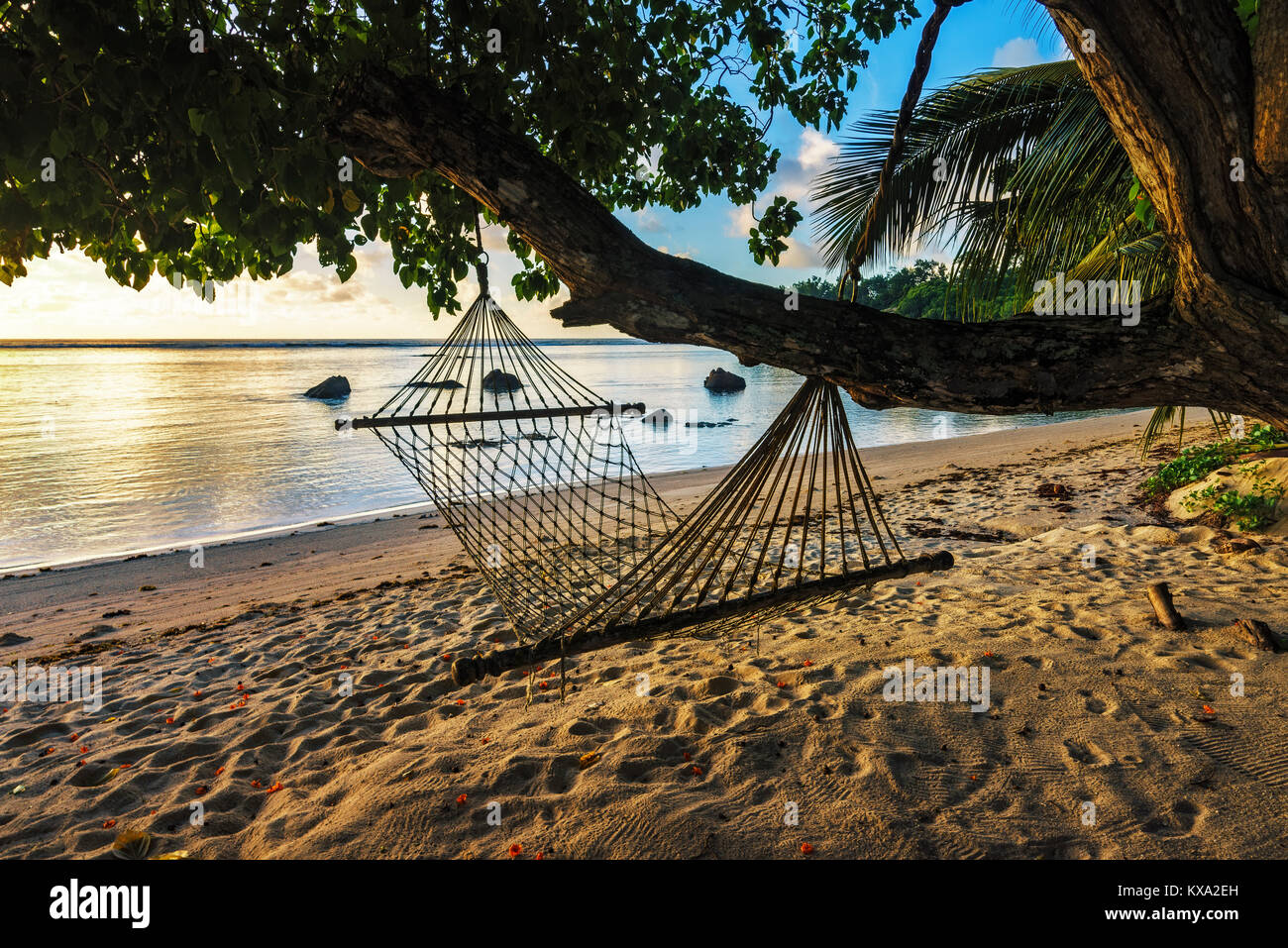 Verlockend, entspannten Hängematte in schönen, goldenen, romantischen Sonnenaufgang am Paradise Beach im Anse aux Pins, Seychellen Stockfoto