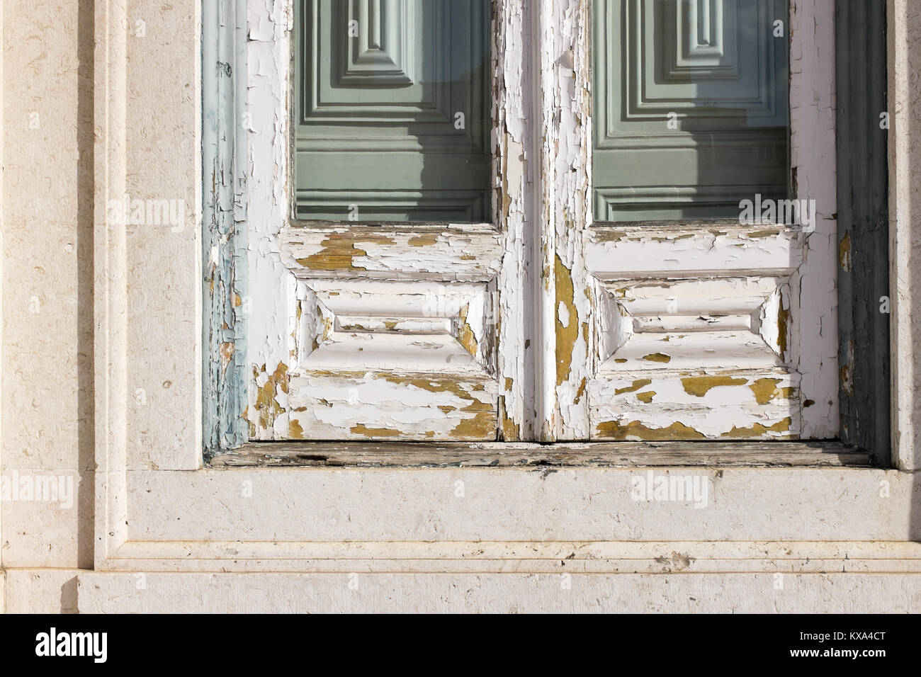 Abblätternde weiße Farbe auf Holz- Fenster mit grünen Fensterläden hinter in Lissabon, Portugal Stockfoto