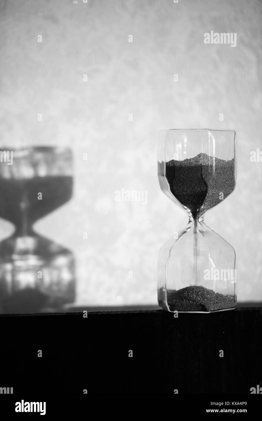 Sanduhr mit Schatten an der Wand. Zeit Konzept für die Frist, die Dringlichkeit und die Zeit läuft. Sanduhr, Eieruhr, die den letzten Minu Stockfoto