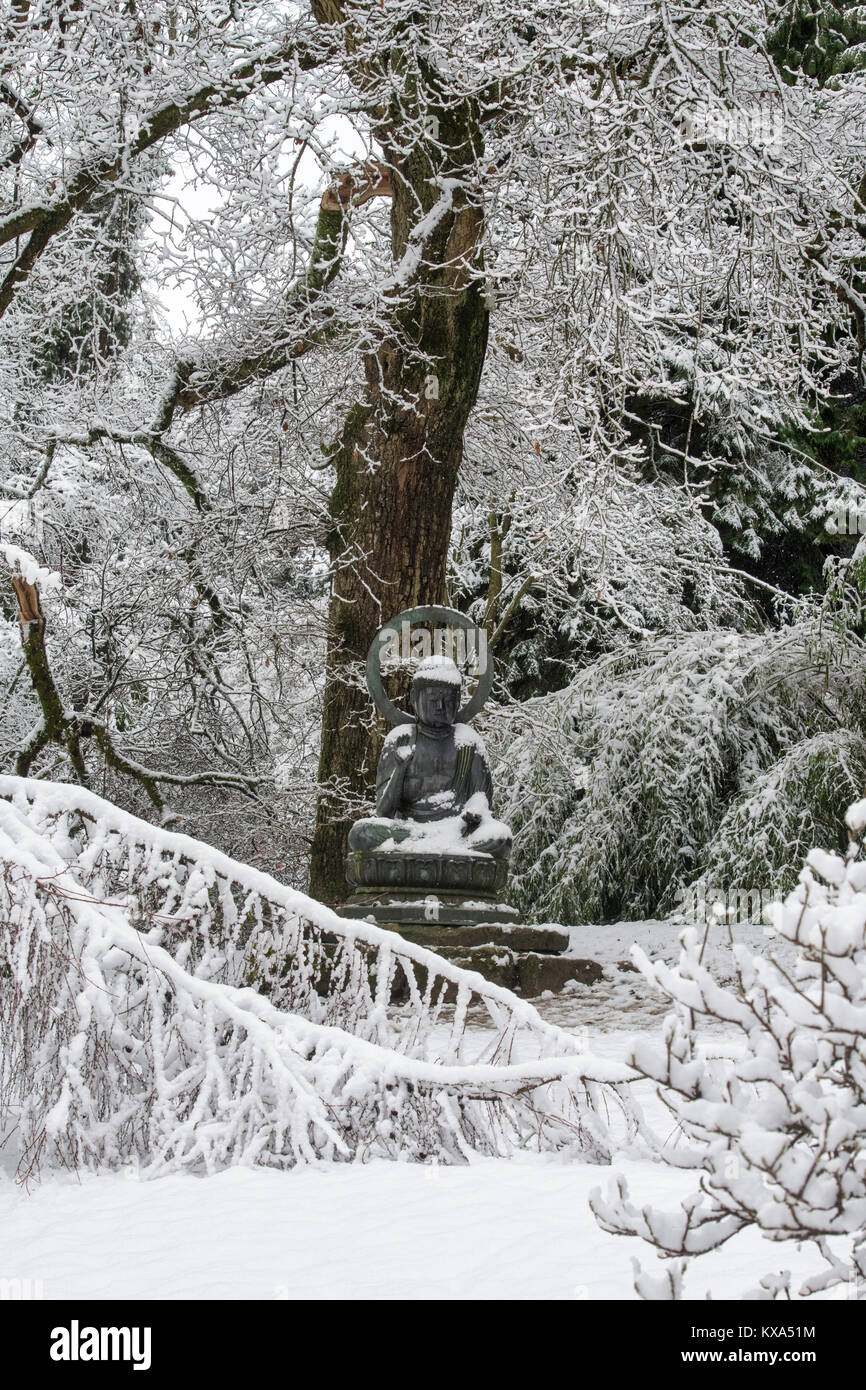 Buddha Statue und Winter Bäume im Schnee im Dezember bei Batsford Arboretum, Cotswolds, Moreton-in-Marsh, Gloucestershire, England Stockfoto