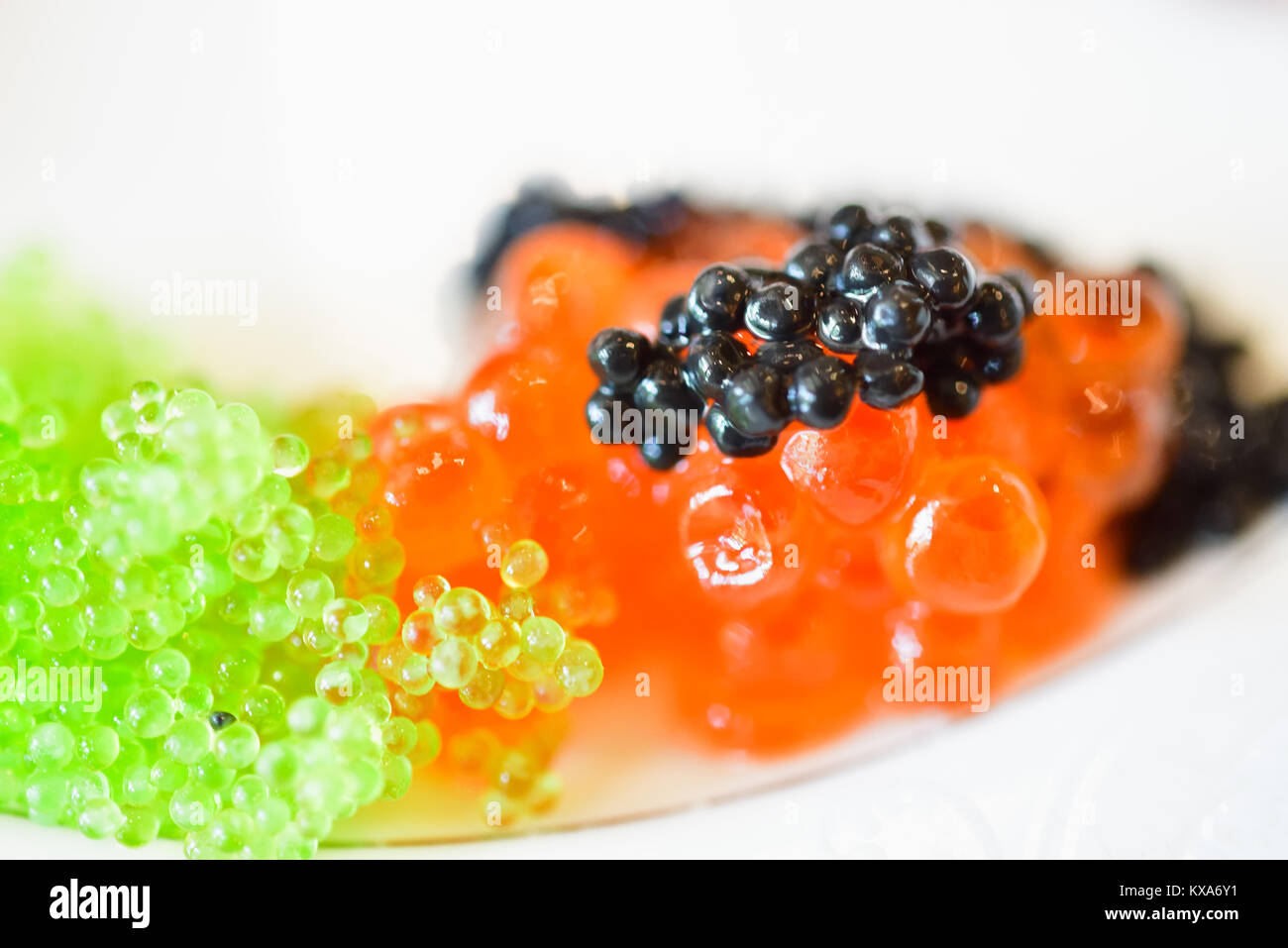Nahaufnahme einer kleinen Portion schwarzen, roten und grünen Kaviar. Nur schwarzen Kaviar ist die tatsächliche Kaviar. Roter Kaviar ist Lachs Rogen, grüne Kaviar ist eine Alge. Stockfoto