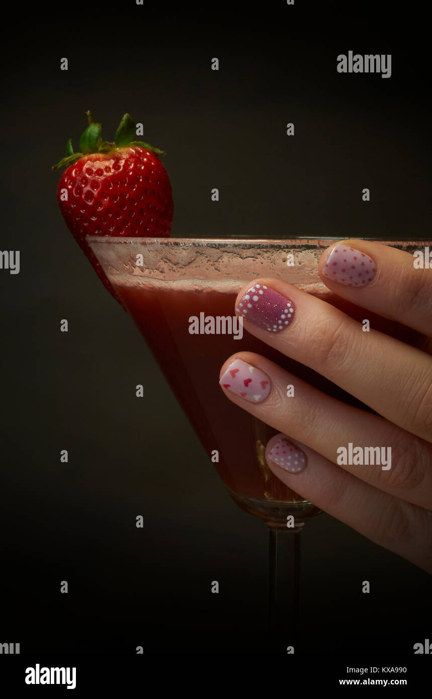 Hand mit lackierten Nägel mit einem Strawberry Daiquiri Stockfoto