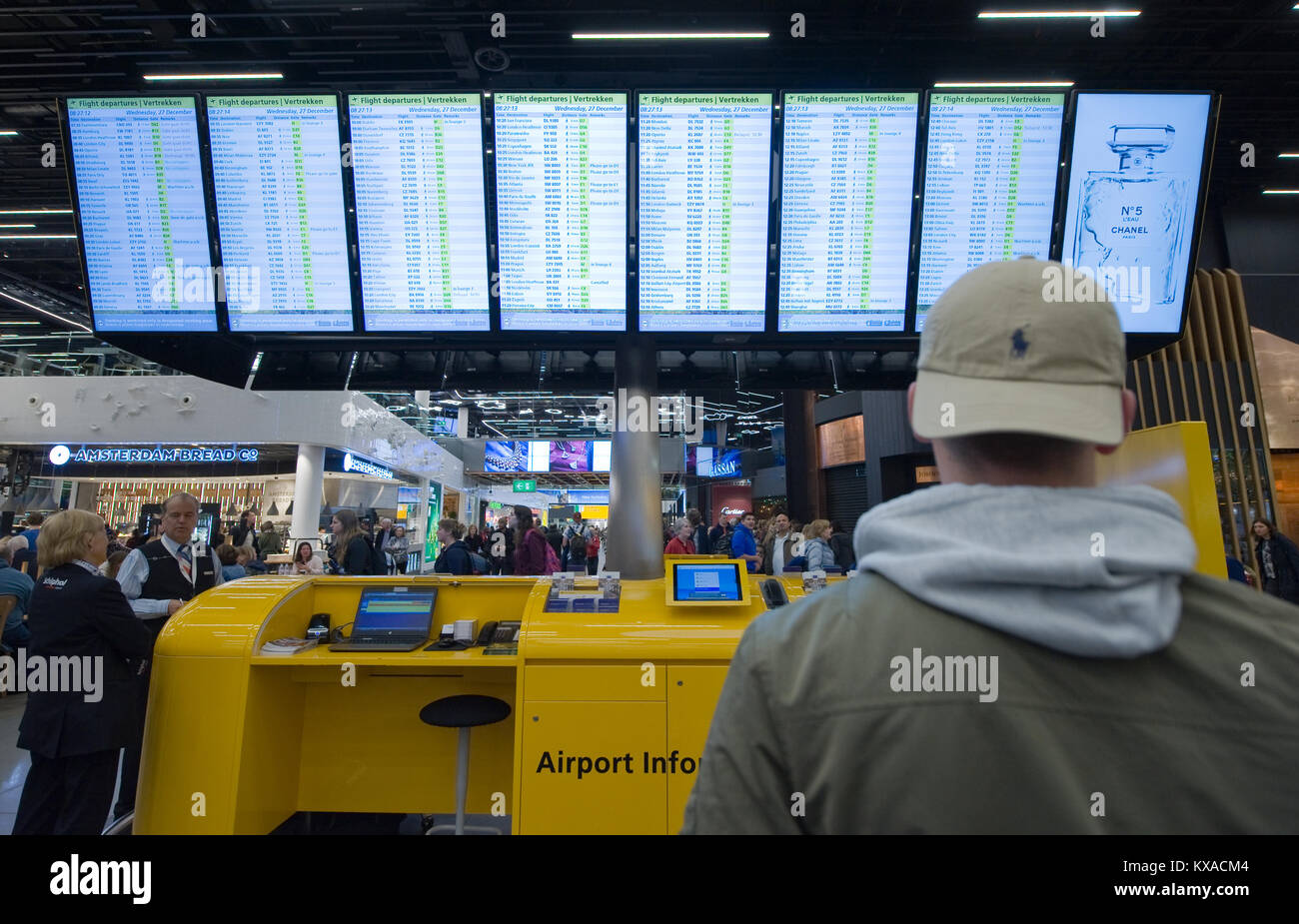 AMSTERDAM, NIEDERLANDE - 27.Dezember 2017: Ein Mann ist mit Blick auf die Informationsseiten seinen Flug am Flughafen Schiphol bei Amsterdam zu prüfen. Stockfoto