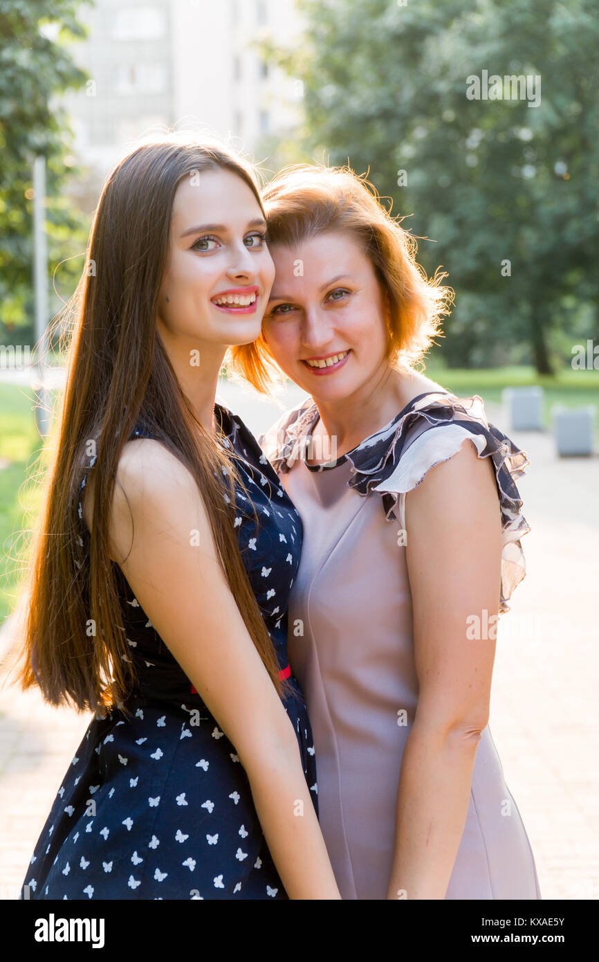 Closeup Portrait von erwachsenen Tochter und Mutter Natur. Hübsche Brünette und ihre Mutter sind auf der Suche in die Kamera im Park im Sommer Stockfoto