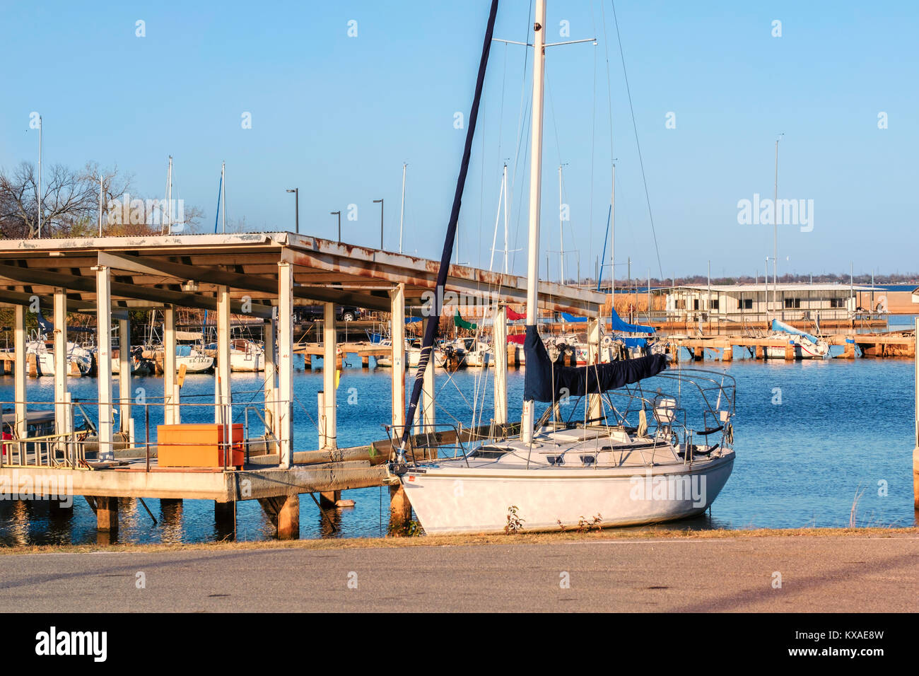 Zwei Segel Cuddy Cabin Segelboot mit eingerollt Segel festgemacht an einem Hefner Lake Marina Dock in Oklahoma City, Oklahoma, USA. Stockfoto
