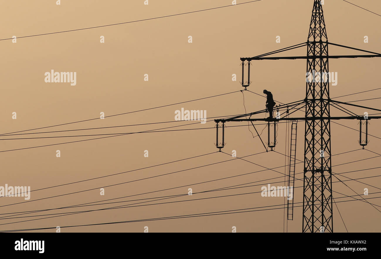 Ein Techniker arbeitet auf die Zeilen eines neuen Transmission Line in luftiger Höhe in der Nähe von Biessenhofen, Deutschland, 08. Januar 2018. Foto: Karl-Josef Hildenbrand/dpa Stockfoto