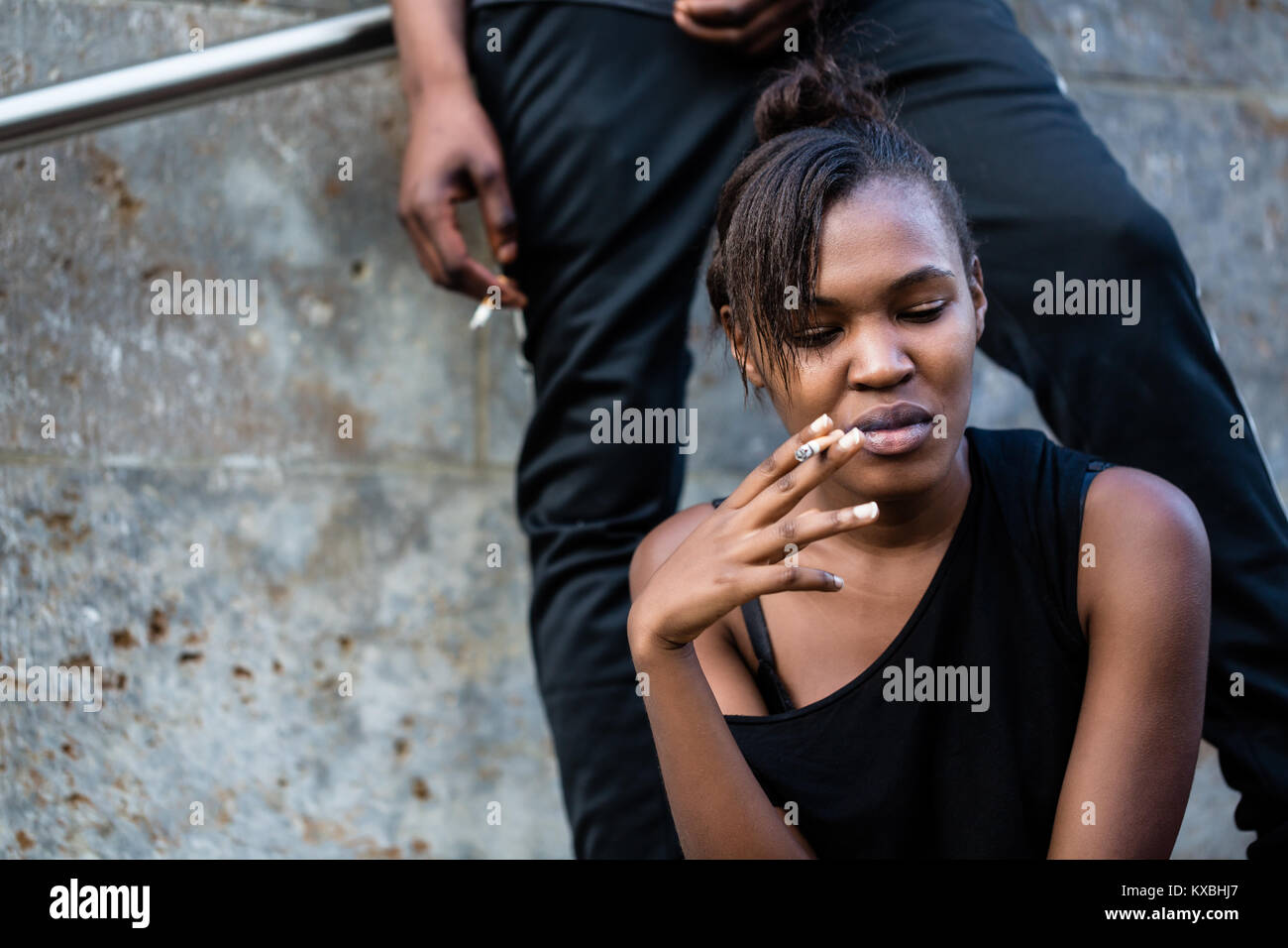 Junge afrikanische amerikanische Frau und Mann Rauchen im Freien in der Cit Stockfoto