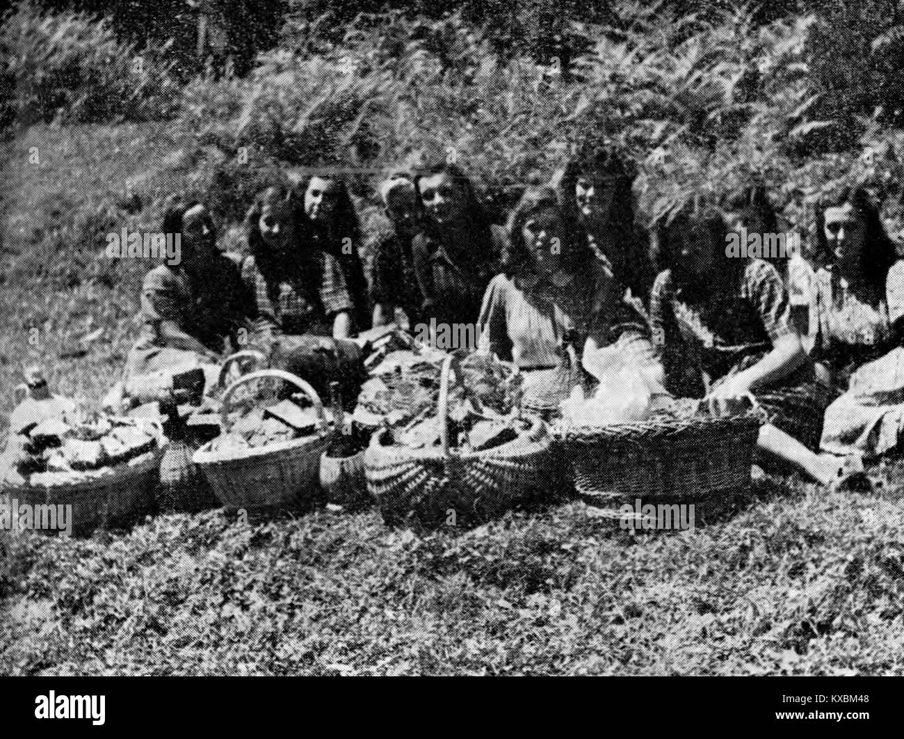 Ein historisches Foto, das junge Frauen zeigt, die verwundeten und erschöpften Soldaten an der Front helfen, und zeigt humanitäre und medizinische Hilfsmaßnahmen während des Krieges in der slowenischen Region. Stockfoto