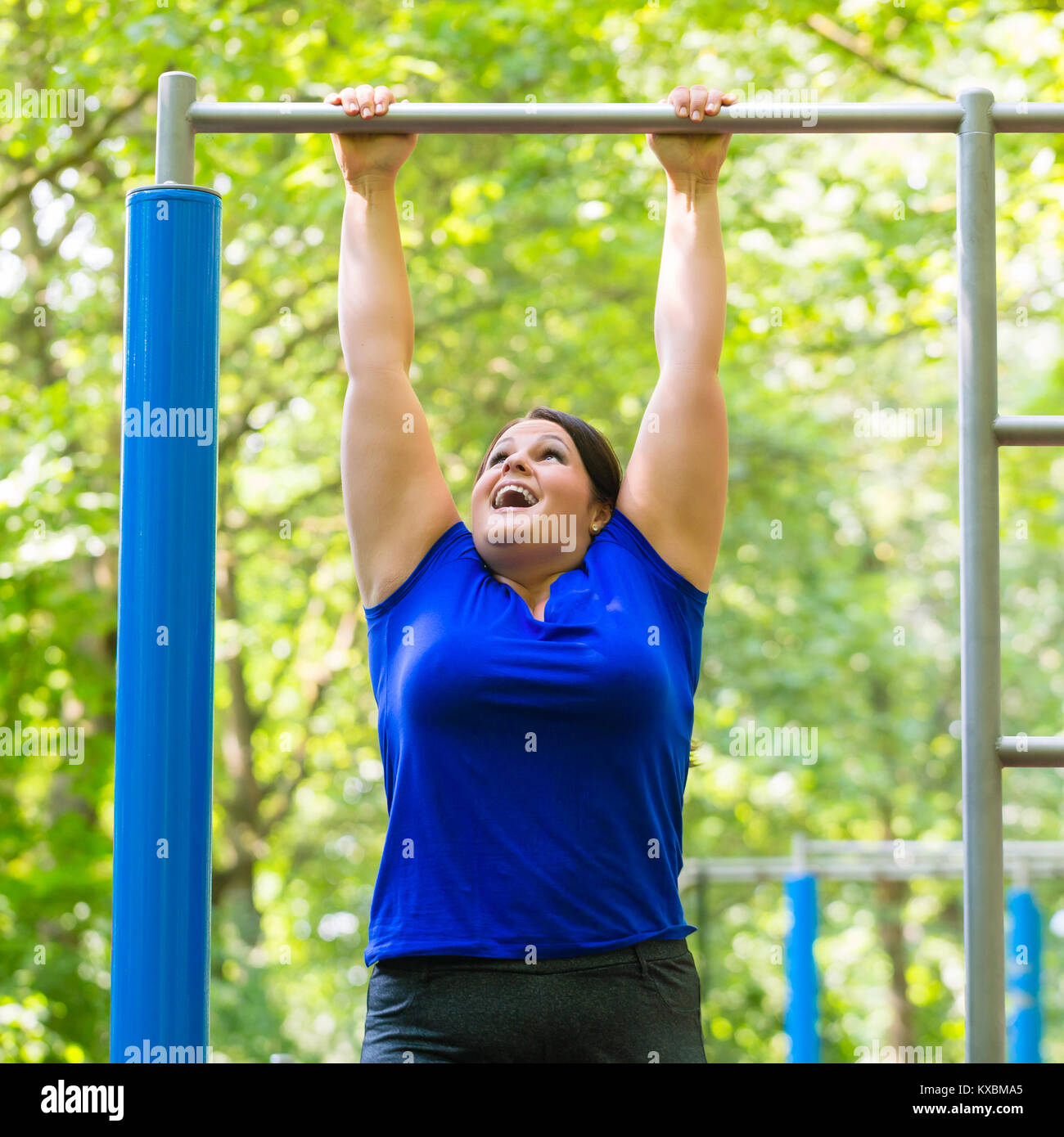 Eine dicke Frau, die sportliche Übungen bei hohen Bar Stockfoto