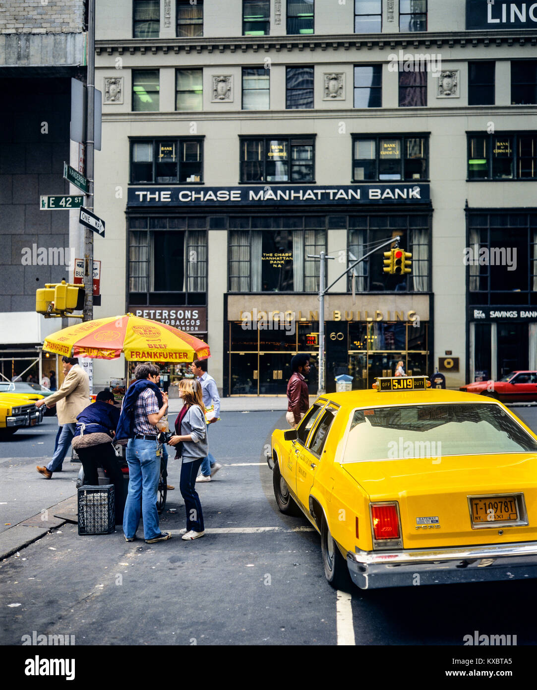 New York 1980s, gelbes Taxi, Frankfurter Würste Food Cart, Menschen, die Chase Manhattan Bank Zweigstelle, Ecke Vanderbilt Avenue und 42. Street, Manhattan, New York City, NY, NYC, USA, Stockfoto