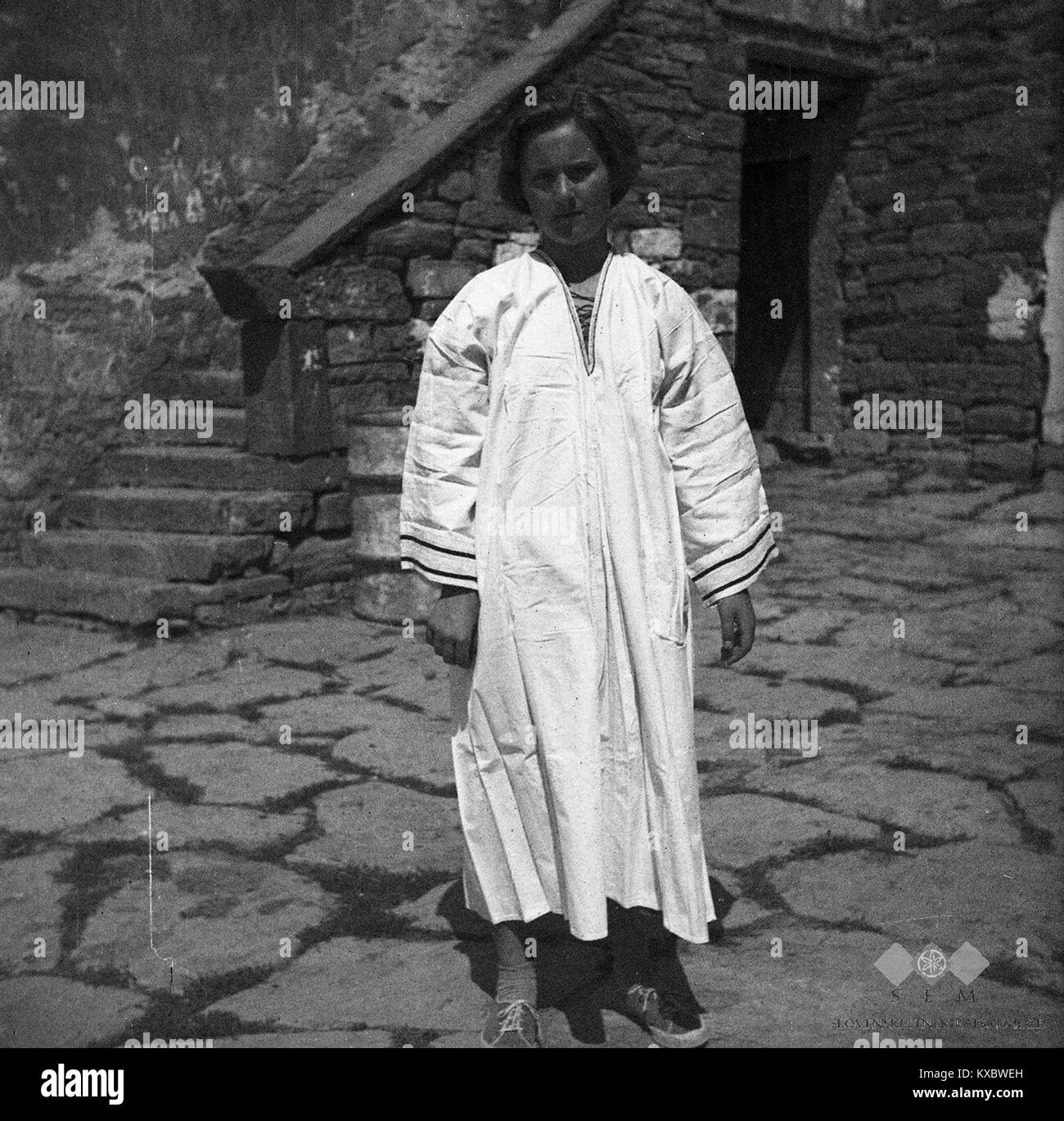 Das Bild zeigt ein traditionelles slowenisches Hochzeitsshirt aus der Zeit der 1950er Jahre mit langen Ärmeln und gestickten Details, das die ländlichen Festkleidungsbräuche in Slowenien Mitte des 20. Jahrhunderts repräsentiert. Stockfoto