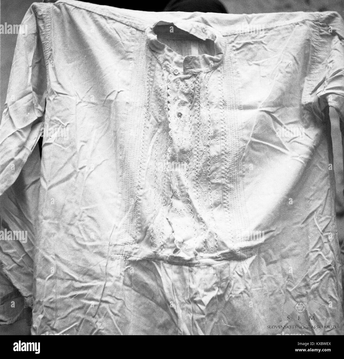 Dieses gestickte Hochzeitsshirt aus dem Jahr 1951, hergestellt in Podbela, Slowenien, zeigt traditionelle slowenische Handwerkskunst und Hochzeitskleidung des frühen 20. Jahrhunderts. Die aufwändige Stickerei spiegelt lokale kulturelle Praktiken wider. Stockfoto