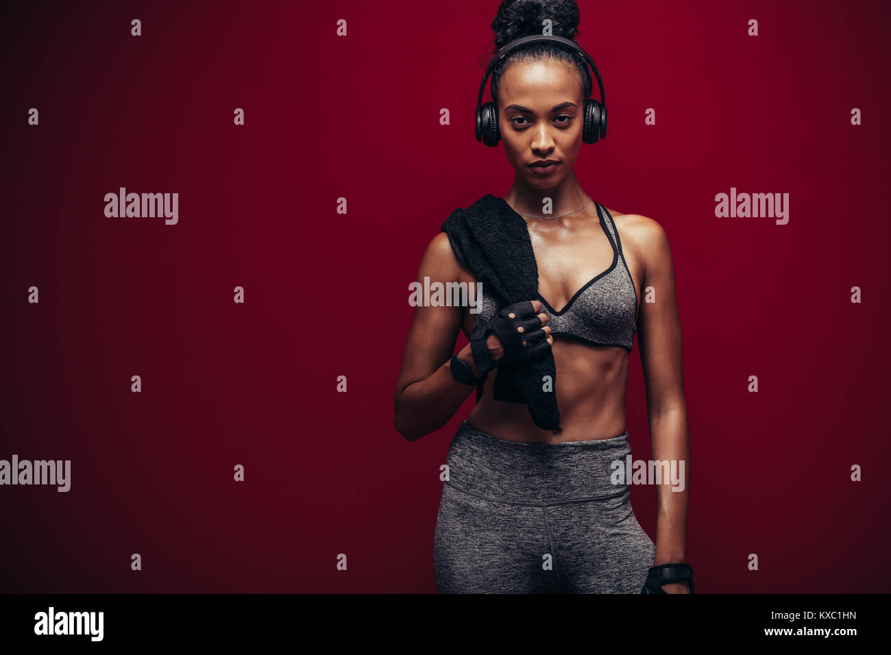 Frau mit perfekten Körper stehend über roten Hintergrund. Afrikanische weiblichen Athleten Ausruhen nach Ihrem Training. Stockfoto