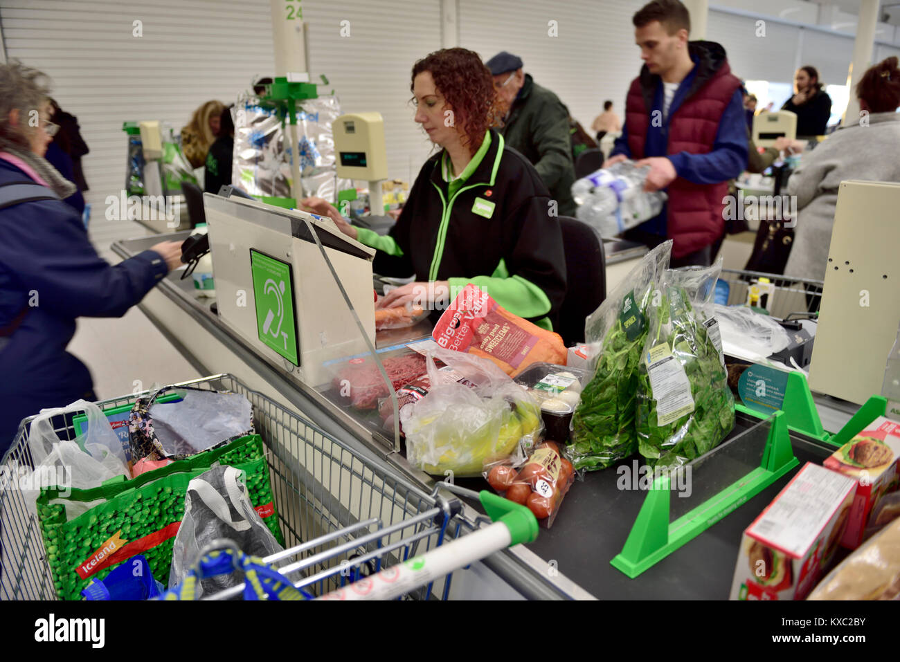 Supermarktkasse bis mit Essen auf Transportband bereit für Kassierer, Großbritannien Stockfoto