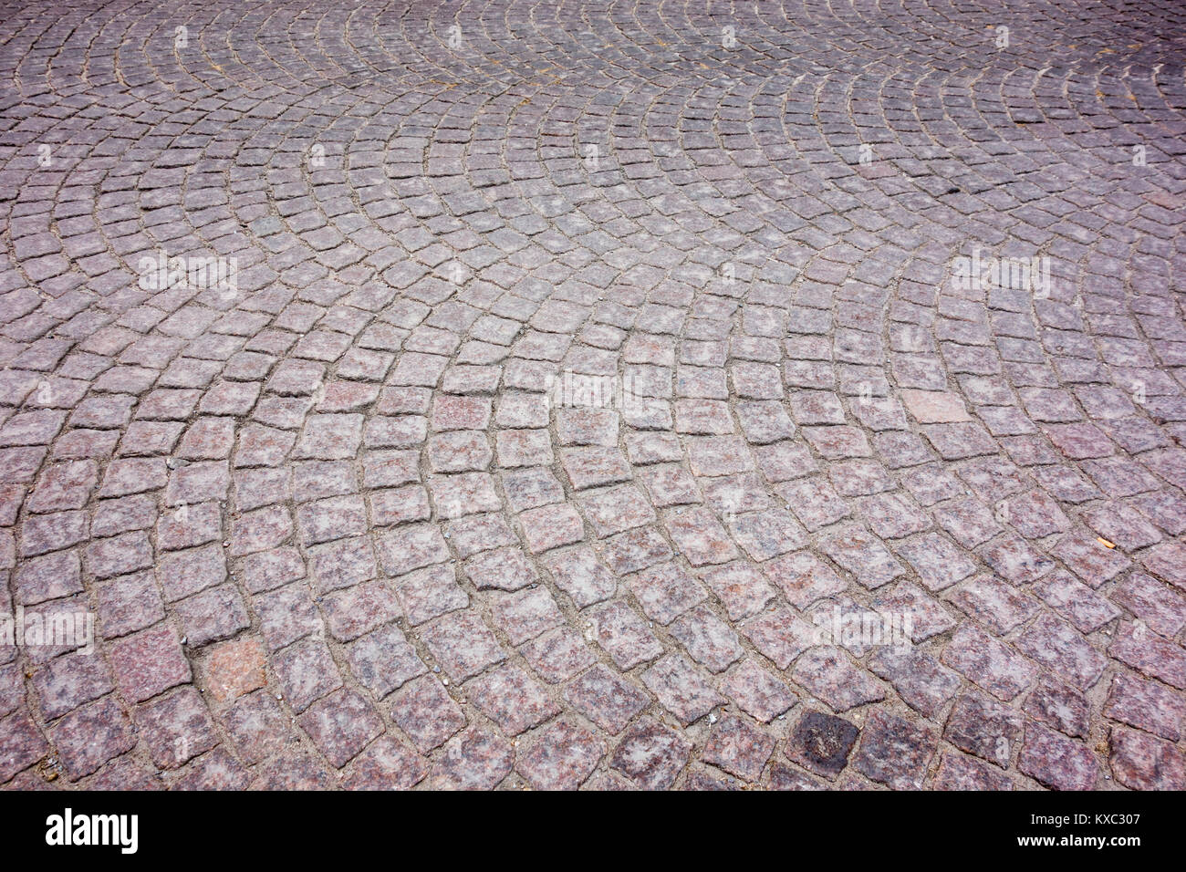 Alte Europäische square Kopfsteinpflaster im Lichtbogen geschwungene Muster angeordnet. Stockfoto