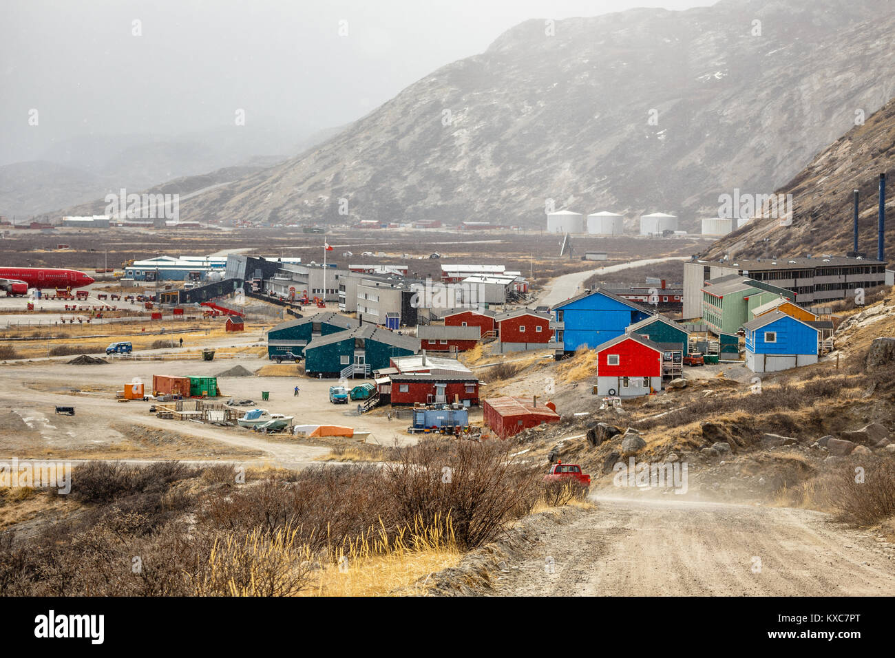 Schneefall und Straße nach Kangerlussuaq Siedlung mit Flughafen und Wohn häuser im Tal zwischen Bergen, Grönland Stockfoto