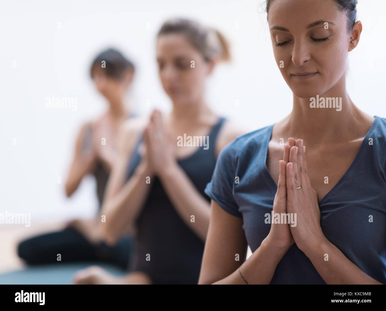 Frauen Yoga und Achtsamkeit Meditation zusammen sind sie umklammern Hände und entspannende, gesunde Lebensweise und Spiritualität Konzept Stockfoto