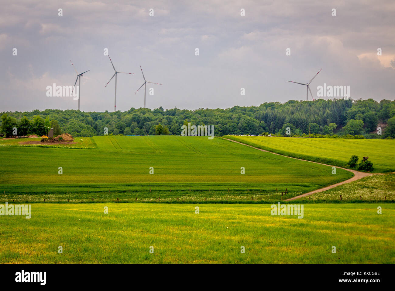 Dieses Foto vom 24. Mai 2015 zeigt Windturbinen am Bostalsee im Saarland und veranschaulicht eine Landschaft mit Infrastruktur für erneuerbare Energien in einer Seenlandschaft. Stockfoto