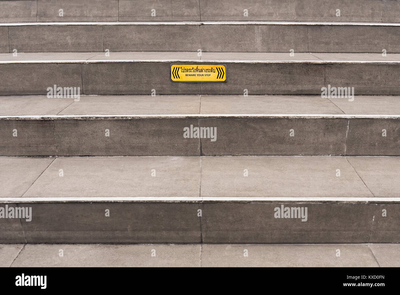 Gepflasterte grau öffentlichen Schritte mit einem gelben "Hüten Sie sich vor ihrem Schritt 'Achtung unterzeichnen. Stockfoto