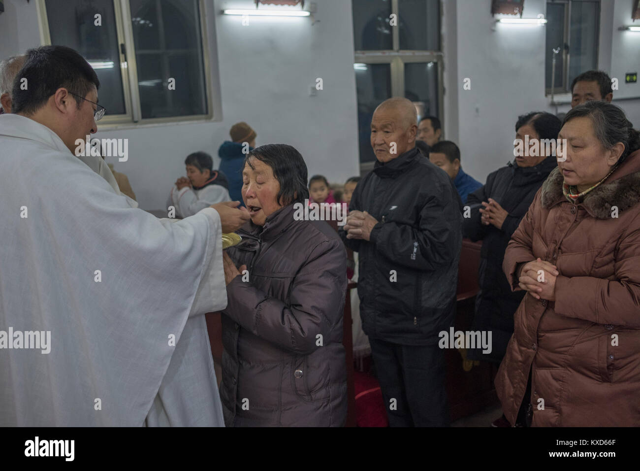 Der Reverend Pang Ruowang, die Gemeinschaft der Gläubigen, während Heiligabend Gottesdienst am Heiligen Herz Jesu Kirche in Housangyu Dorf, 70 km westlich von Peking entfernt, eine der frühesten Kirchen in China. 24-Dez-2017 Stockfoto