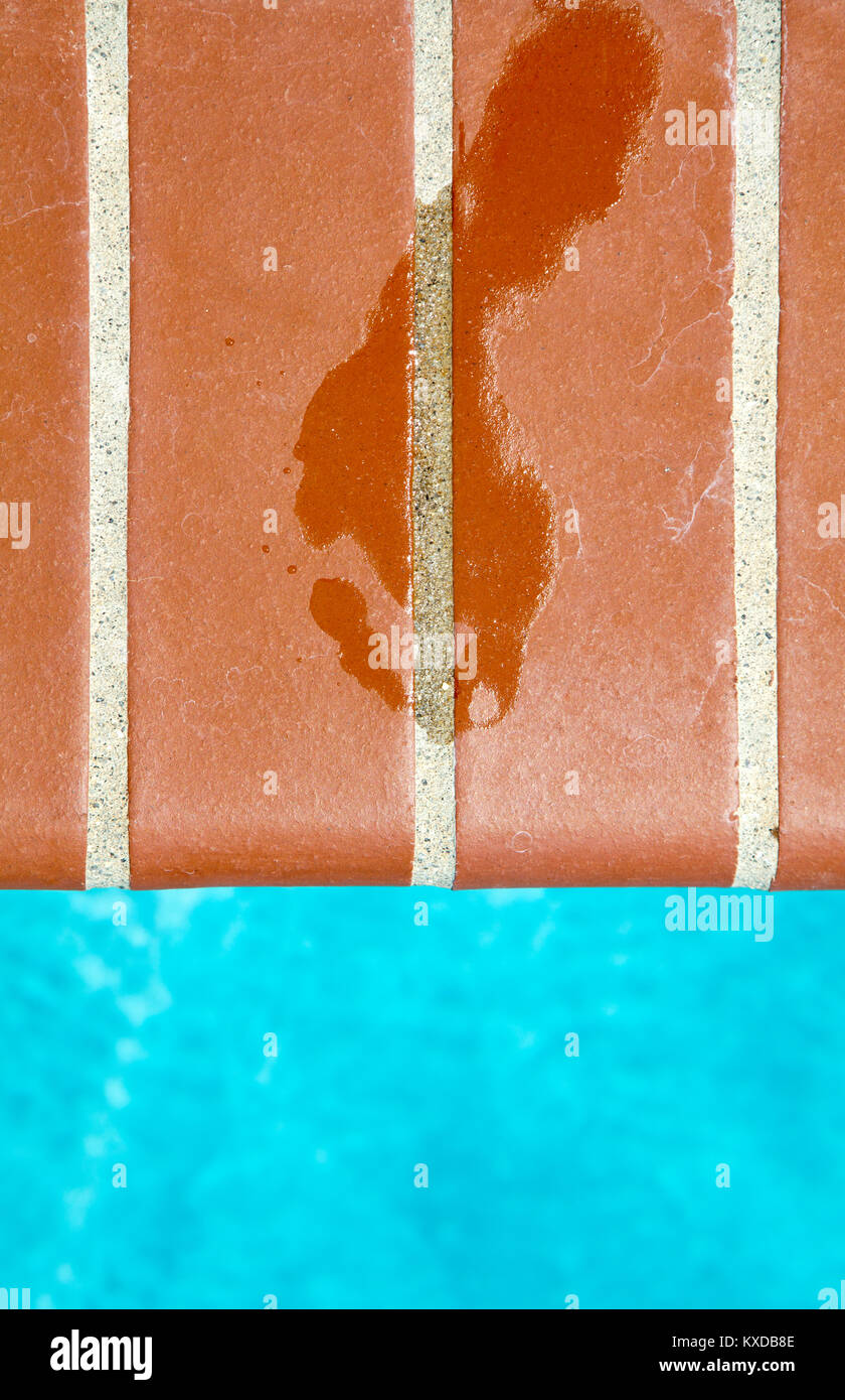 Nasse männliche Fußabdruck am Beckenrand Stockfoto