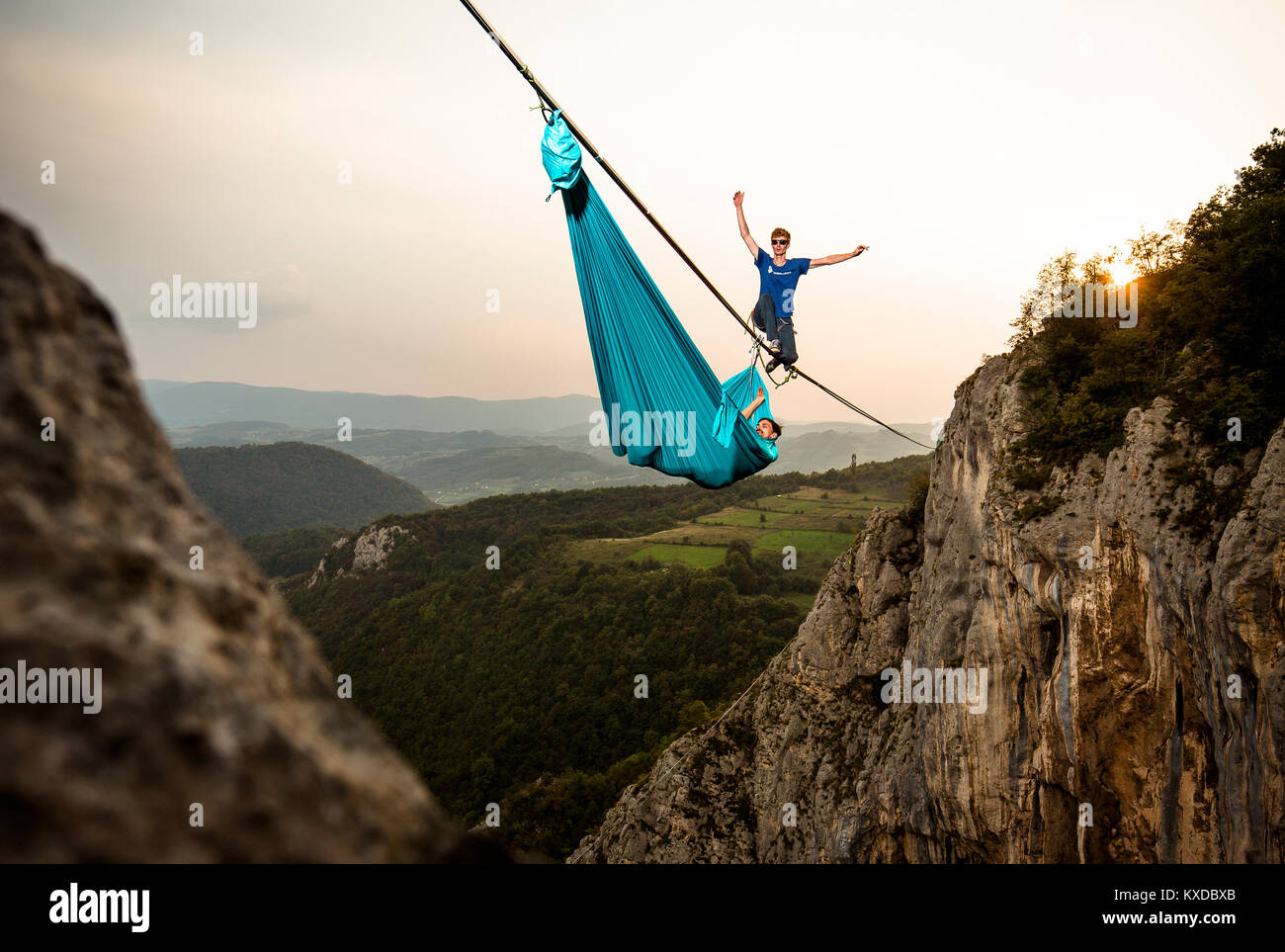 Highline Athlet zu Fuß auf slackline in Berge, während seine Kollegen hängen in Hängematte, Tijesno Canyon, Banja Luka, Bosnien Stockfoto