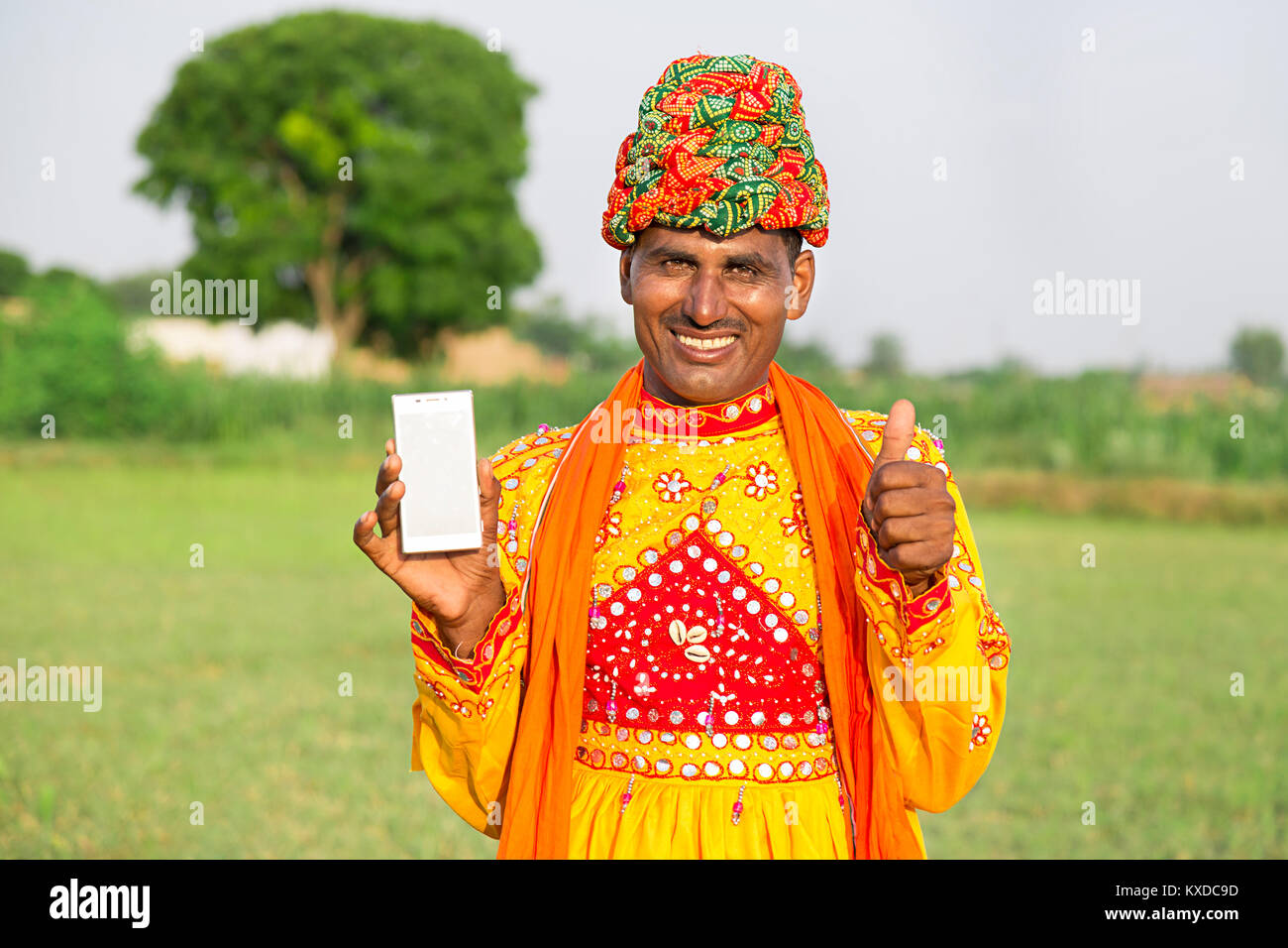 1 Indischen ländlichen Gujrati Mann Feld mit Thumbsup mit Smartphone Stockfoto