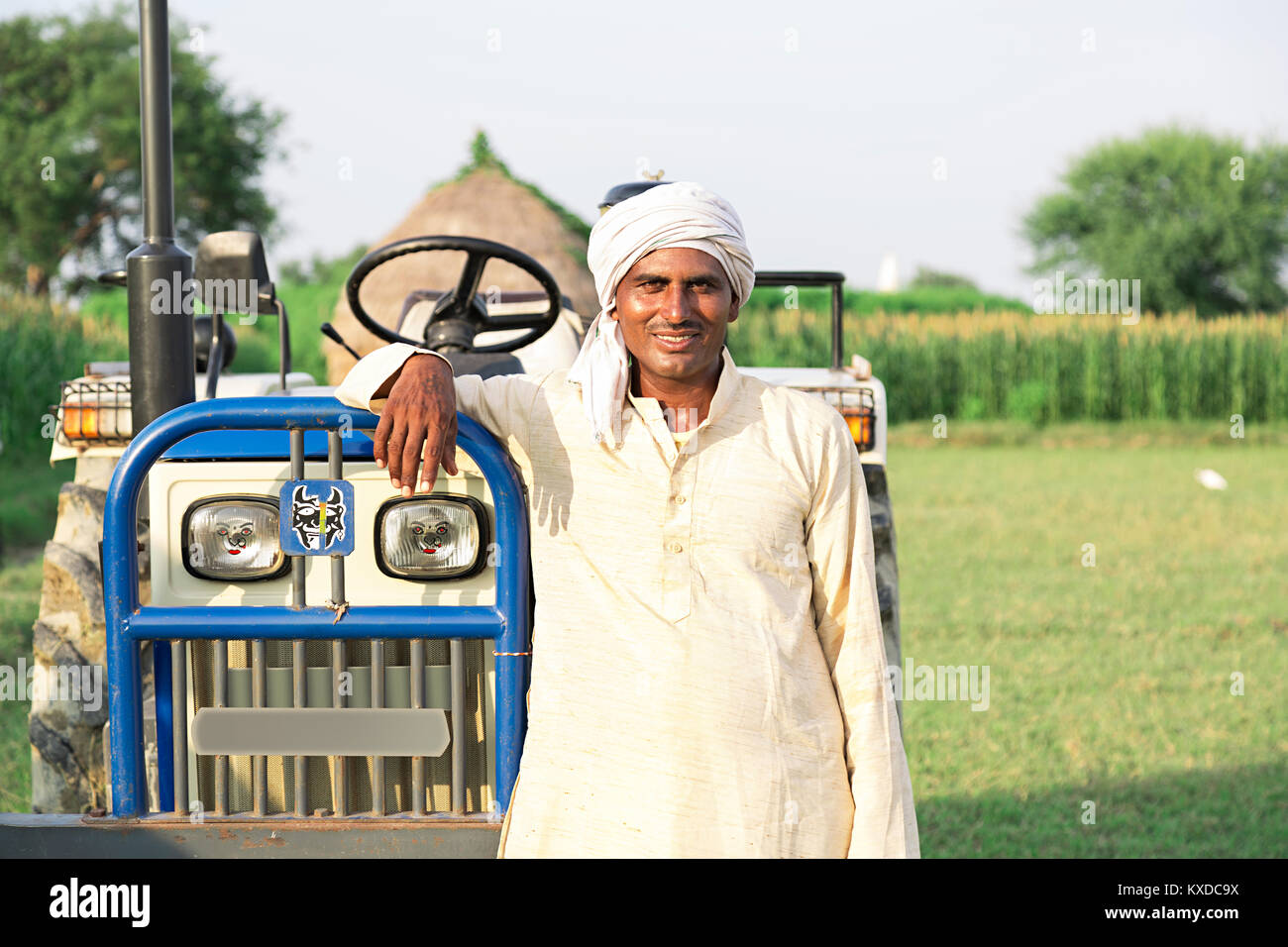Lächelnd 1 Indischen ländlichen Bauern Mann stand in der Nähe von Traktor Farm Stockfoto