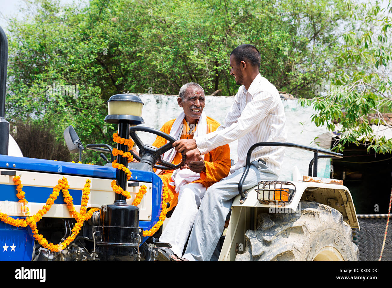 2 Indischen ländlichen Bauern Vater und Sohn reiten Traktor Dorf Stockfoto