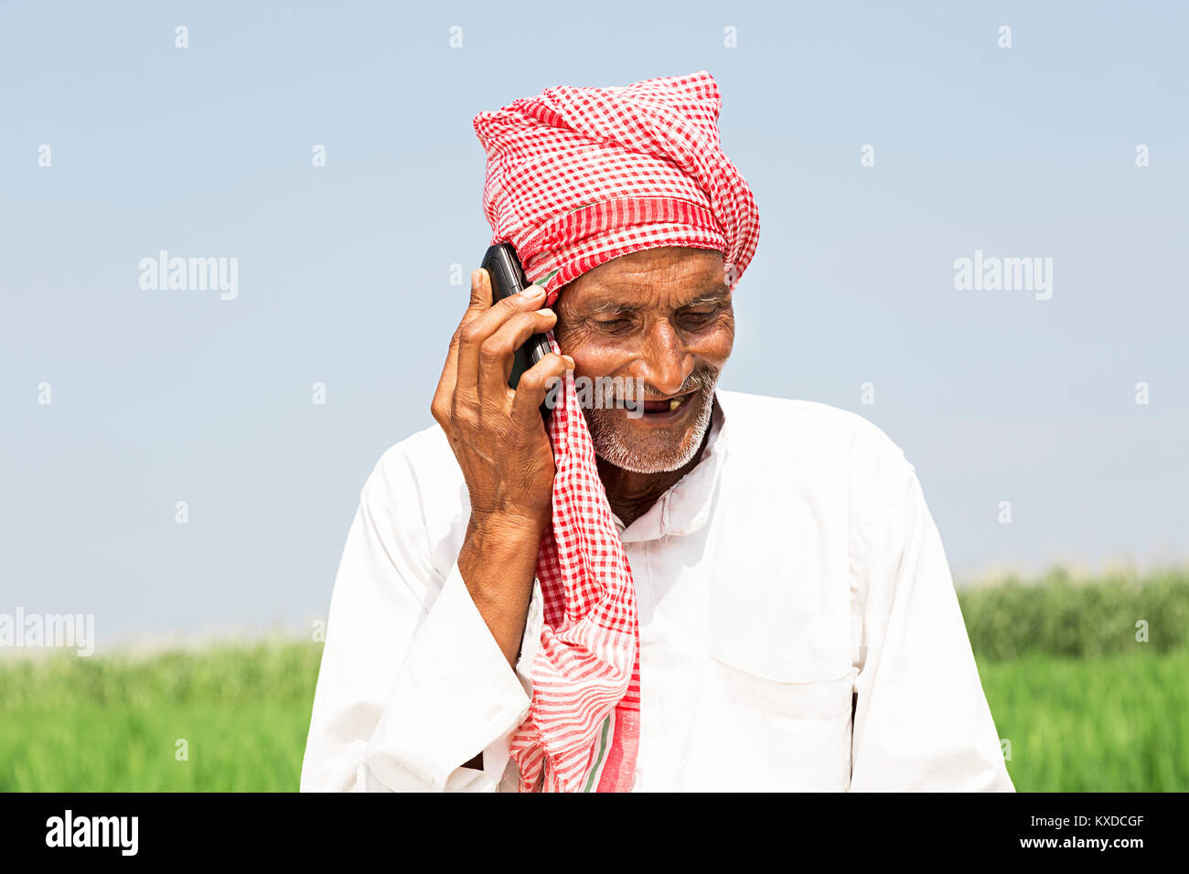 1 Indischen ländlichen Bauern älterer Mann lächelnd im Gespräch Telefon Farm Stockfoto