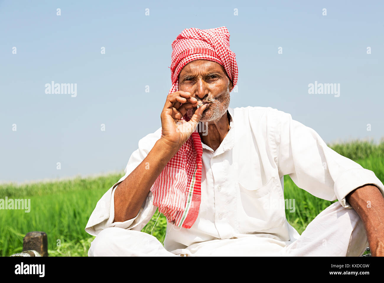 1 Indischen ländlichen Bauern alte Mann sitzt Bauernhof Rauchen Bidi Stockfoto