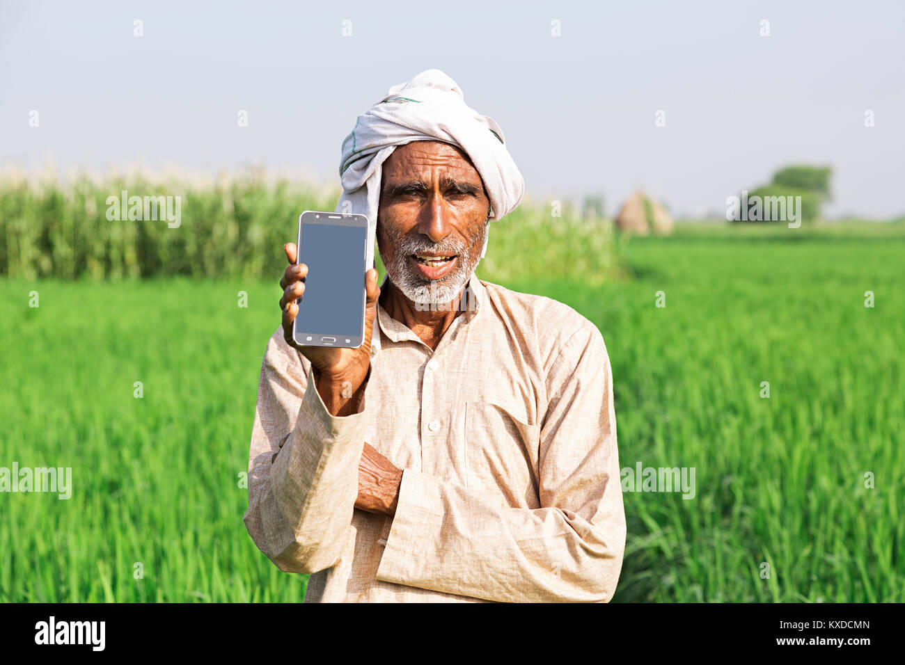 1 Indischen ländlichen Bauern alter Mann mit Handy Feld Stockfoto