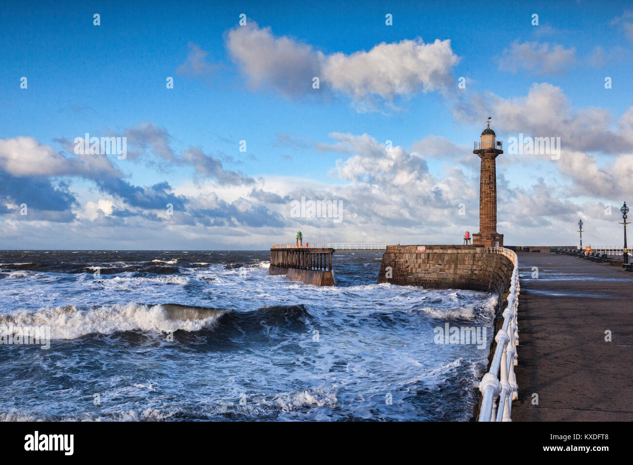 Wind und eine steigende Flut produzieren raue See am Eingang zum Hafen von Whitby, North Yorkshire, auf einem hellen Winter am Nachmittag. Stockfoto