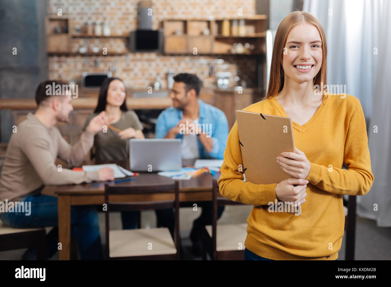 Aufgeregt, fröhliche Frau glücklich lächelnd, während man mit einem Ordner Stockfoto