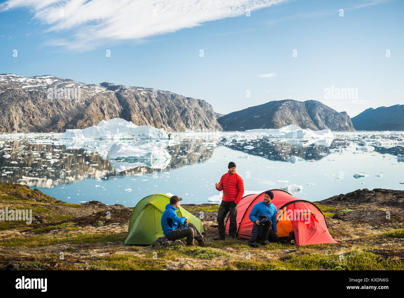 Drei Leute mit Zelten, Rot und Grün, die Berge, Fjorde und Eisberge, Grönland Stockfoto