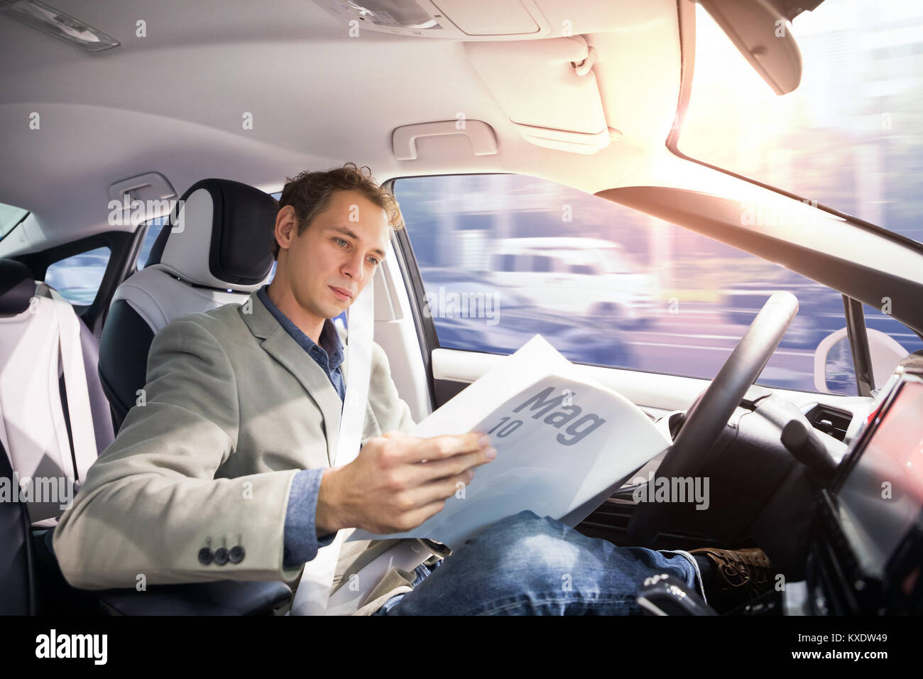 Kaukasische Treiber lesen Magazin in autonomen Auto. Selbst das Fahrzeug fahren. Fahrerlose Auto. Stockfoto