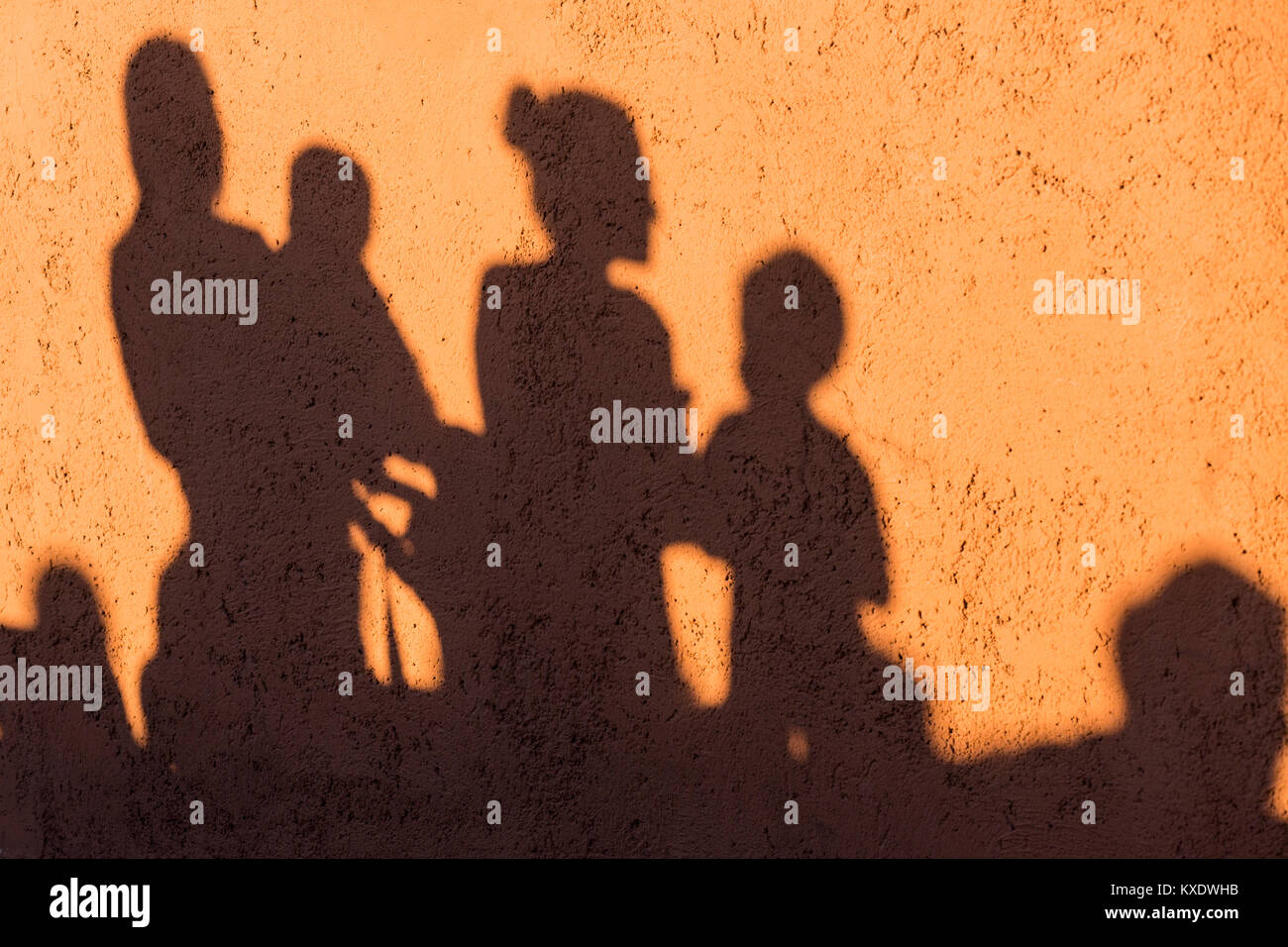 Schatten einer Familie, Mutter, Vater, zwei Kinder auf eine rote Wand Stockfoto