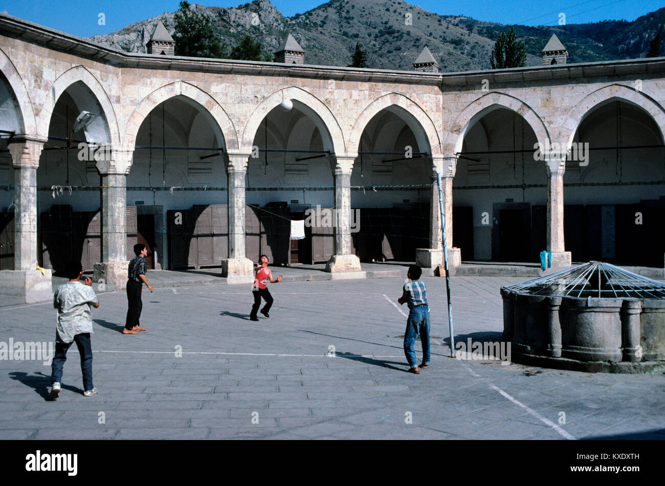 Türkische Jungs, Volleyball oder Fußball im achteckigen Innenhof des c 15 Buyuk Aga Medresse oder Kapi Aga Medresesi, Amasya, Türkei Stockfoto